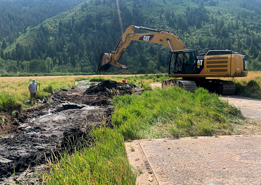 The plug was constructed with spoils collected onsite. Protective pads were placed beneath the heavy machinery.